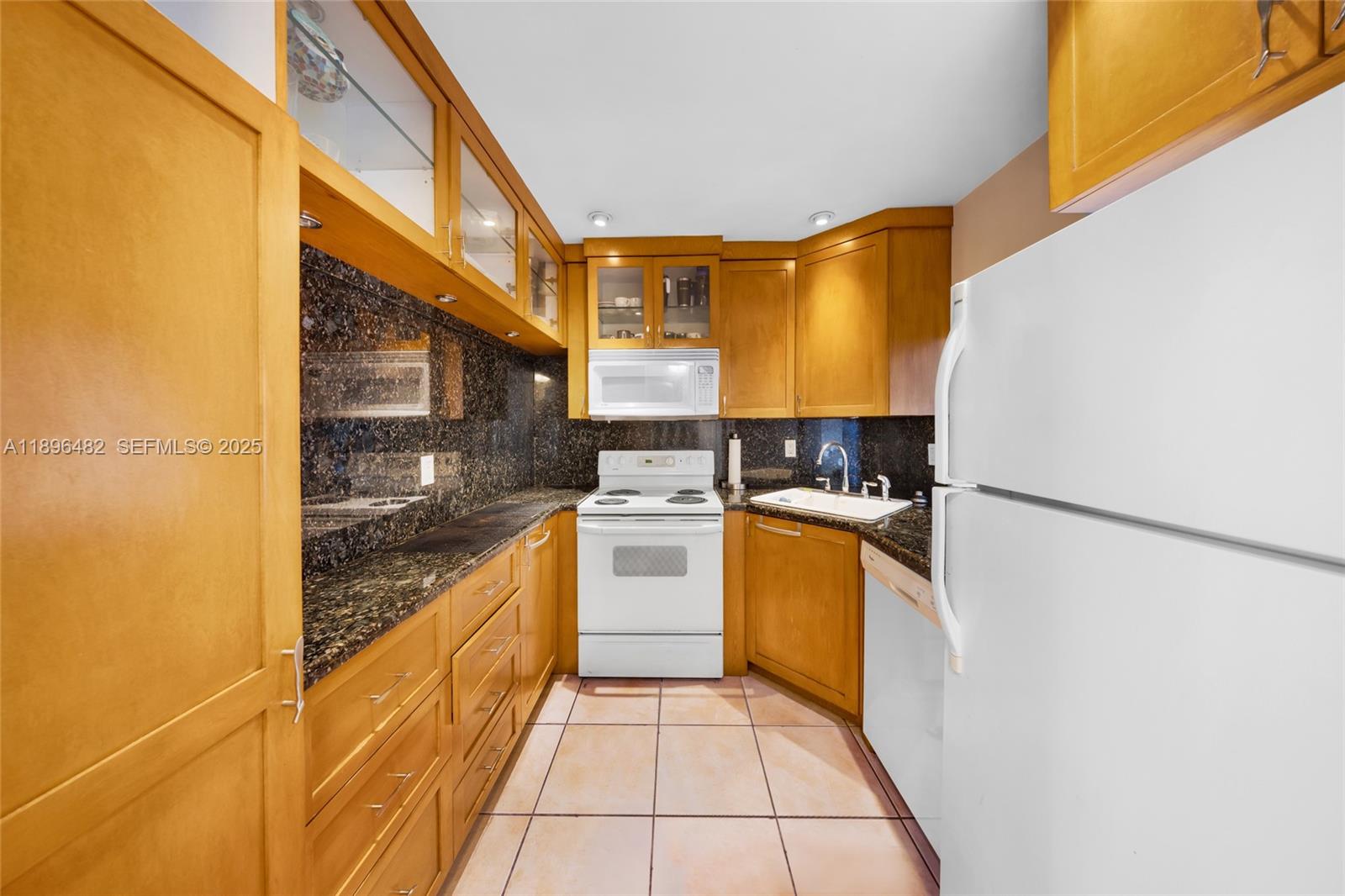 6545 Indian Creek Drive, Unit 504 Miami Beach, FL 33141 - Photo 13 of 38 a kitchen with stainless steel appliances granite countertop a refrigerator and a stove