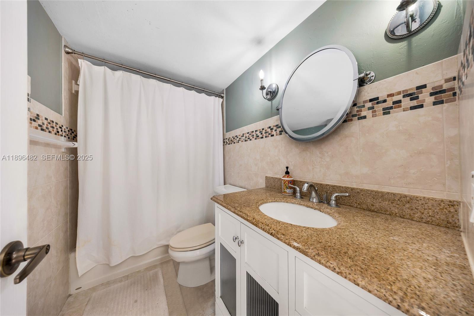 6545 Indian Creek Drive, Unit 504 Miami Beach, FL 33141 - Photo 20 of 38 a bathroom with a granite countertop sink mirror toilet and shower