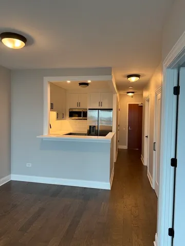 a view of a room with wooden floor and a window