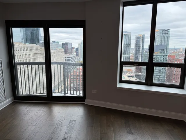 an empty room with wooden floor and windows