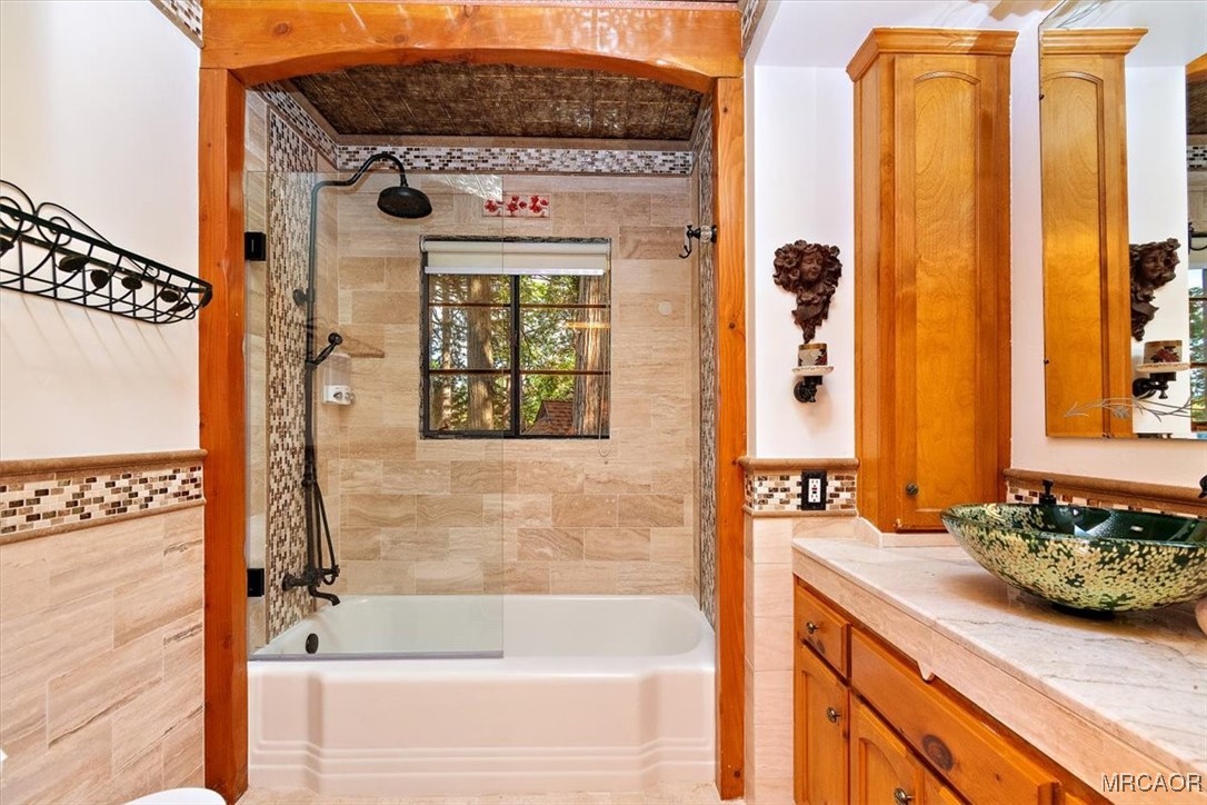 329 Summit Road Lake Arrowhead, CA 92352 - Photo 27 of 50 a bathroom with a granite countertop sink a mirror and a bathtub