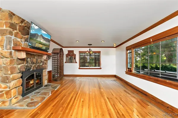 a view of empty room with floor to ceiling window and fireplace