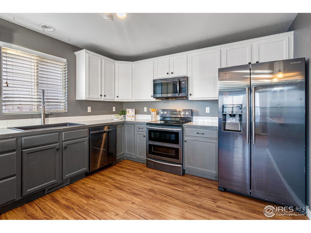 628 Sumac Street Frederick, CO 80530 - Photo 16 of 38 a kitchen with stainless steel appliances granite countertop a refrigerator a sink dishwasher a stove with wooden floor