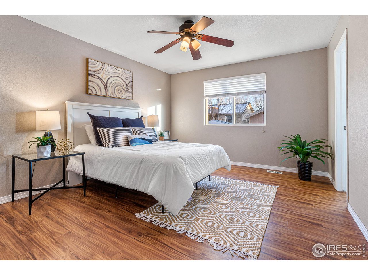 628 Sumac Street Frederick, CO 80530 - Photo 19 of 38 a bedroom with a large bed a chandelier and a potted plant