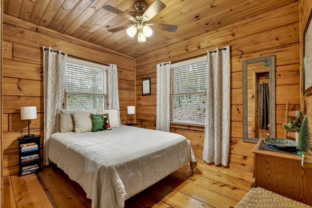 488 Joann Sisson Road Blue Ridge, GA 30513 - Photo 25 of 39 a spacious bedroom with a large bed and a chandelier