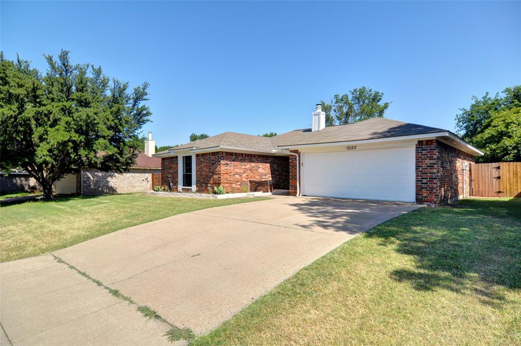 Ranch-style home featuring brick siding, an attached garage, concrete driveway, and a chimney