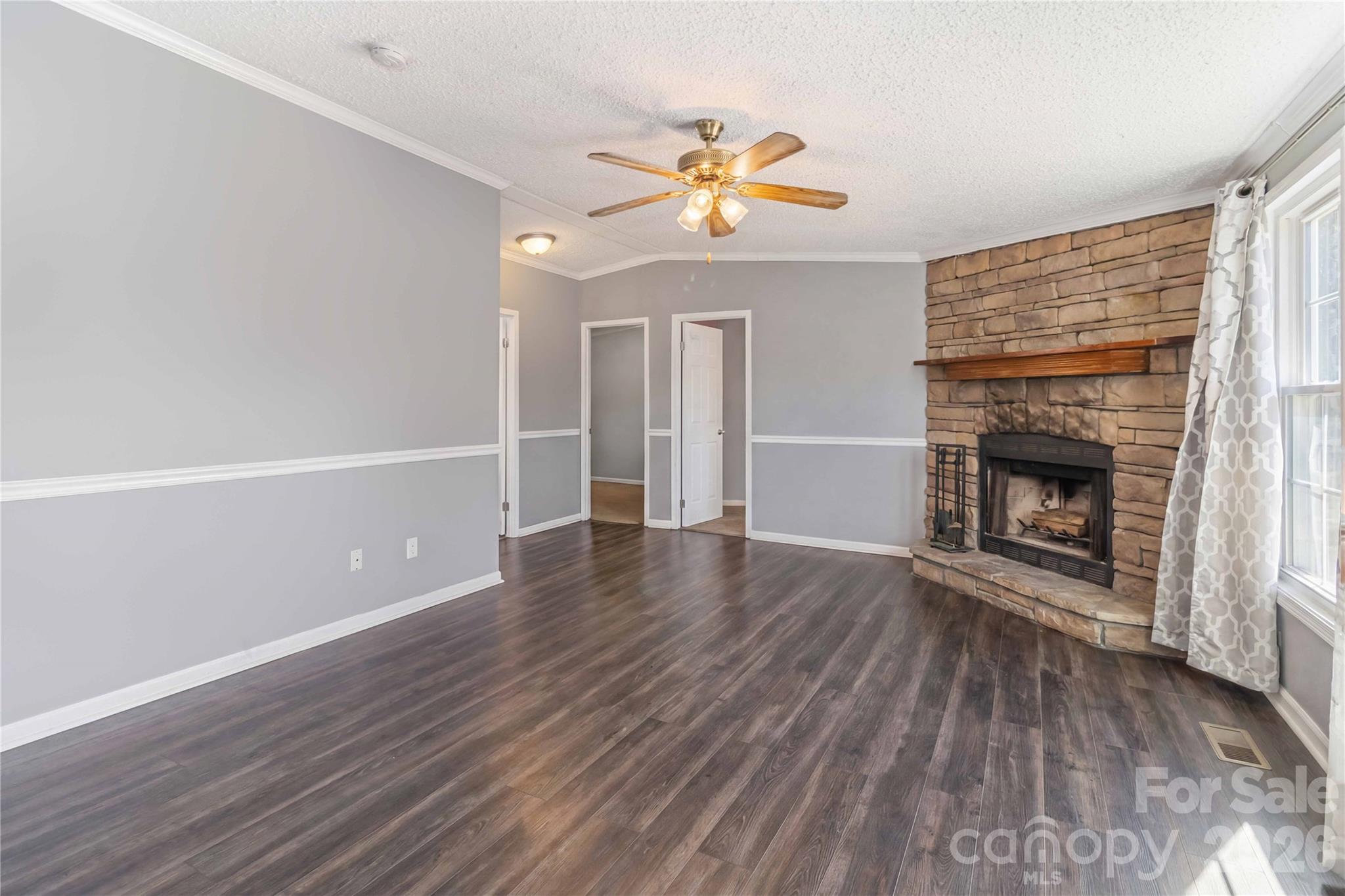 482 Pine Road Jefferson, SC 29718 - Photo 22 of 39 an empty room with wooden floor fireplace and windows