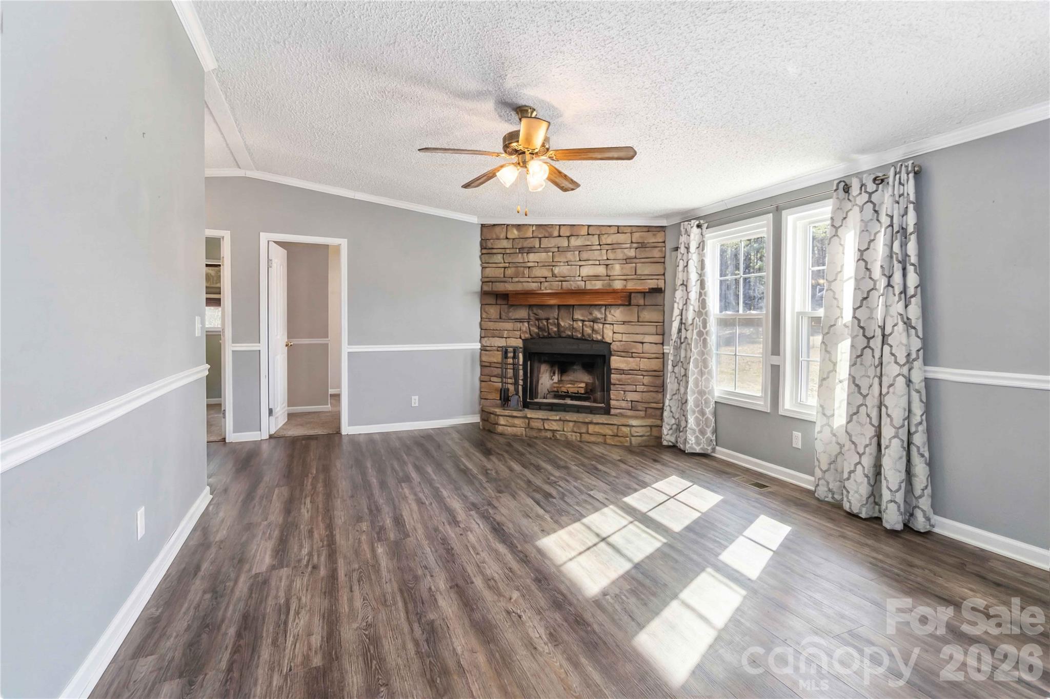 482 Pine Road Jefferson, SC 29718 - Photo 23 of 39 an empty room with windows fireplace and wooden floor