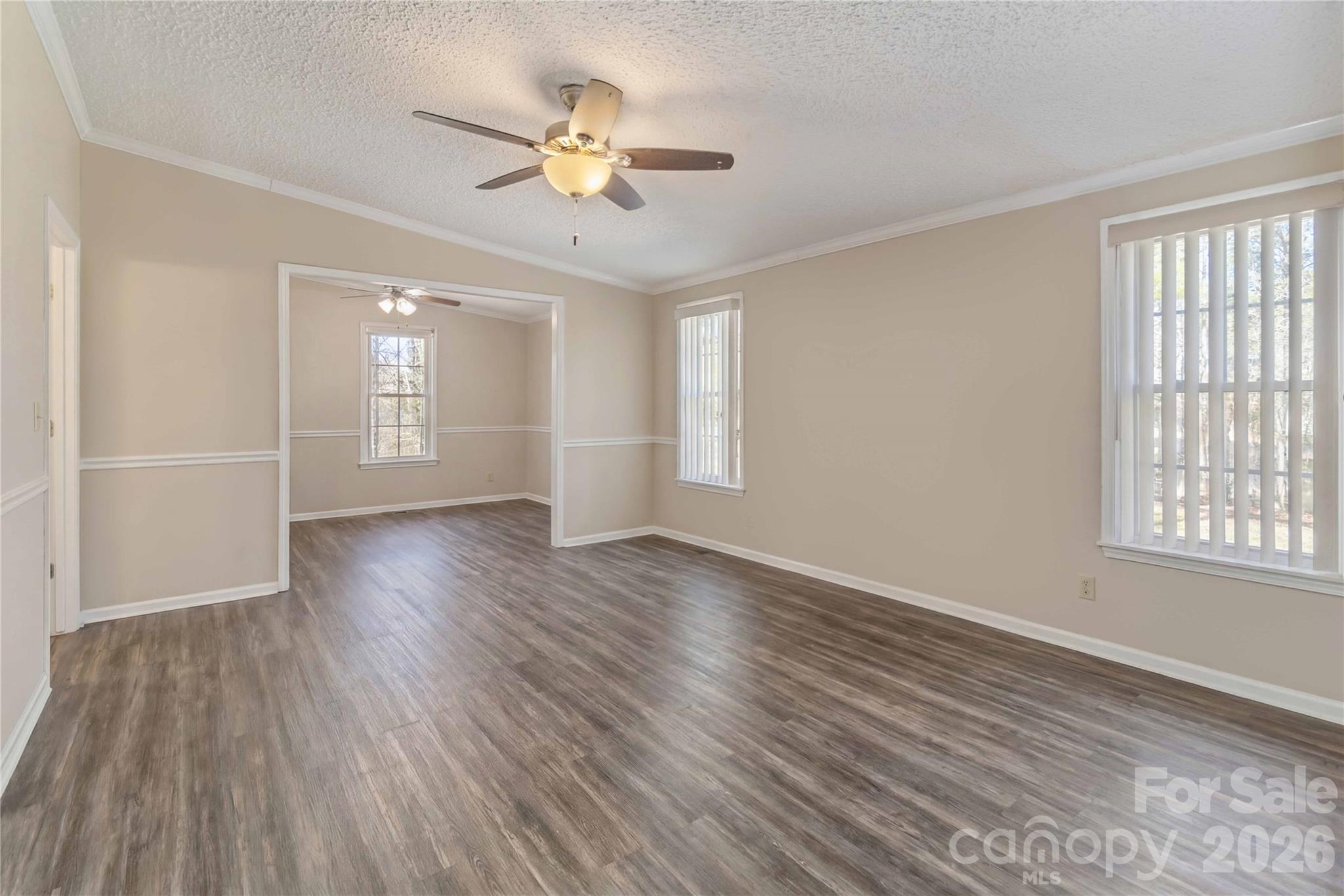 482 Pine Road Jefferson, SC 29718 - Photo 28 of 39 an empty room with wooden floor chandelier fan and windows