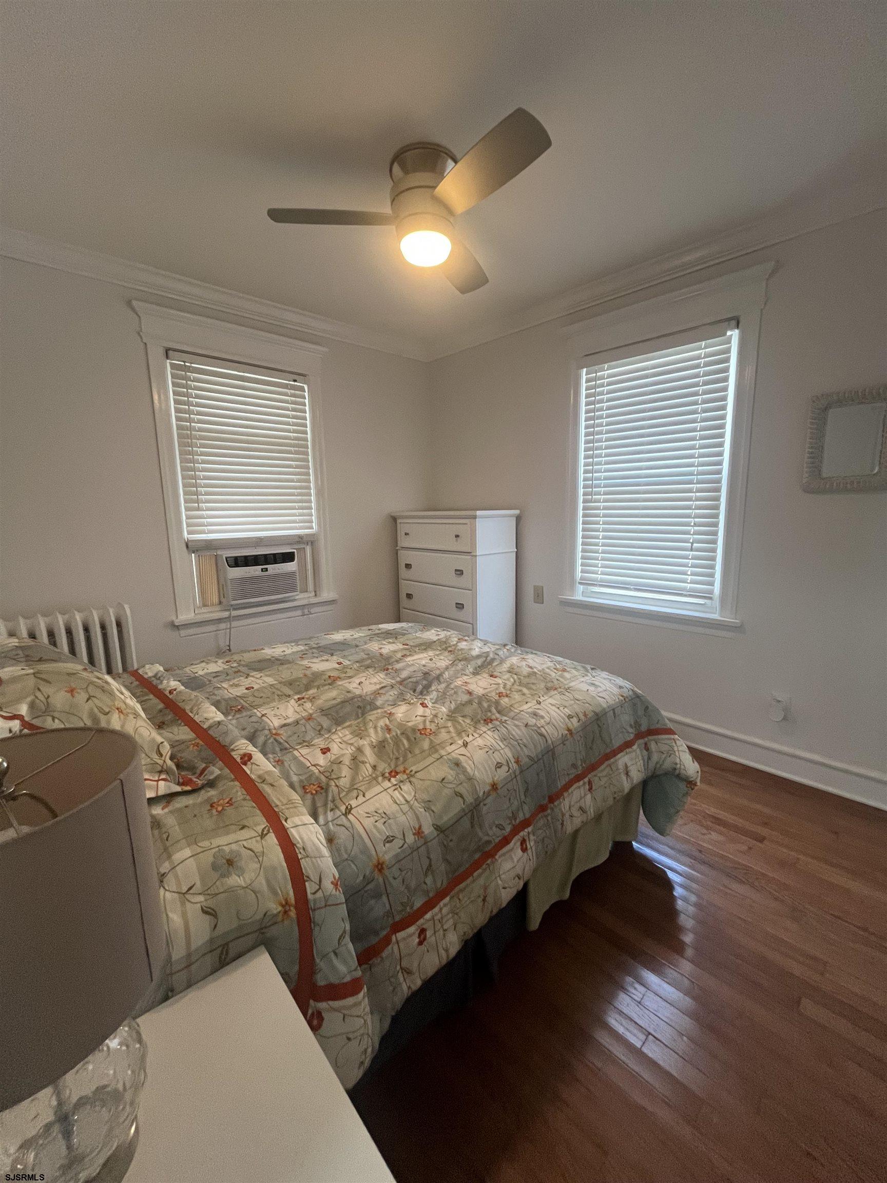 15 North Melbourne Avenue, Unit WINTER 2025 Ventnor City, NJ 08406 - Photo 12 of 15 a bedroom with a bed and a window