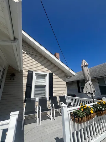 a front view of a house with barbeque oven table and chairs