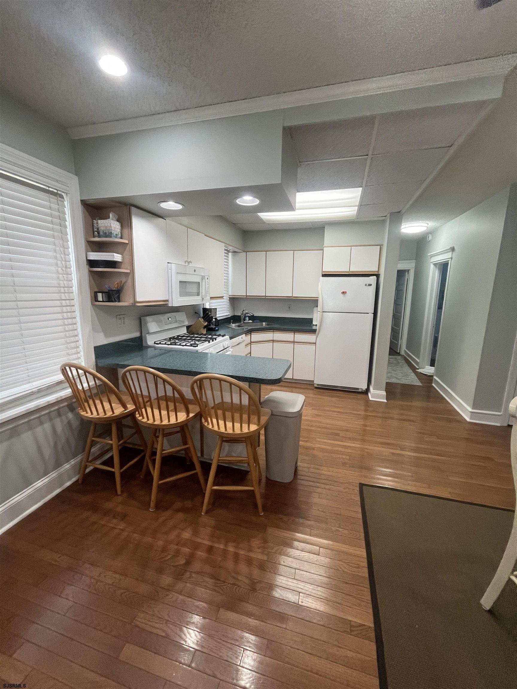 15 North Melbourne Avenue, Unit WINTER 2025 Ventnor City, NJ 08406 - Photo 9 of 15 a view of a dining room with furniture and wooden floor