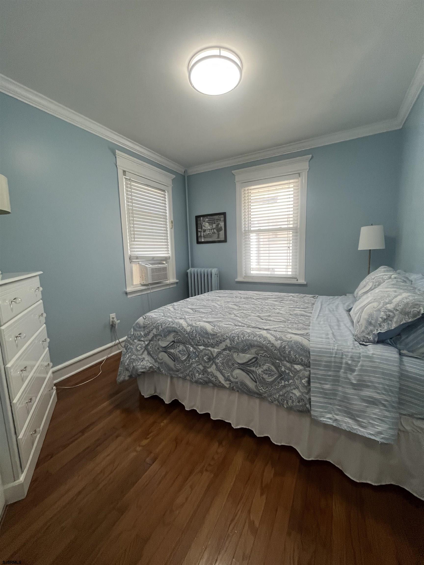 15 North Melbourne Avenue, Unit WINTER 2025 Ventnor City, NJ 08406 - Photo 10 of 15 a bedroom with a bed and wooden floor
