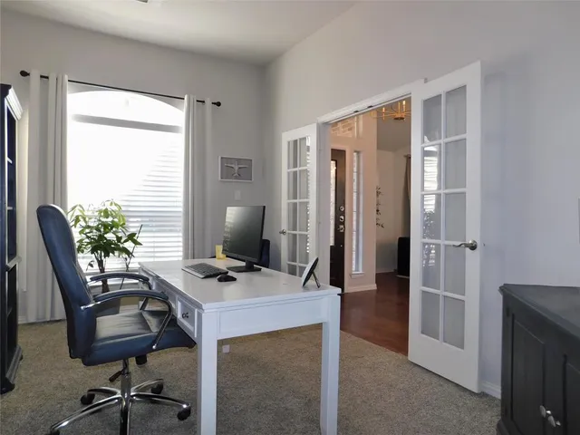 a view of a workspace with furniture and a window