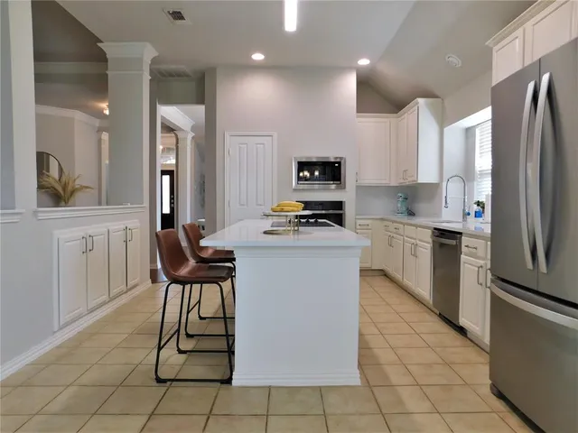 a kitchen with stainless steel appliances a refrigerator sink and microwave