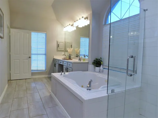 a bathroom with a tub a sink and a shower