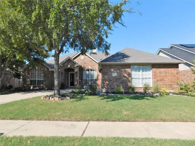 a front view of a house with a yard and trees