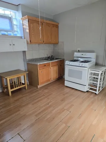 a kitchen with stainless steel appliances granite countertop a sink a stove and a wooden floors