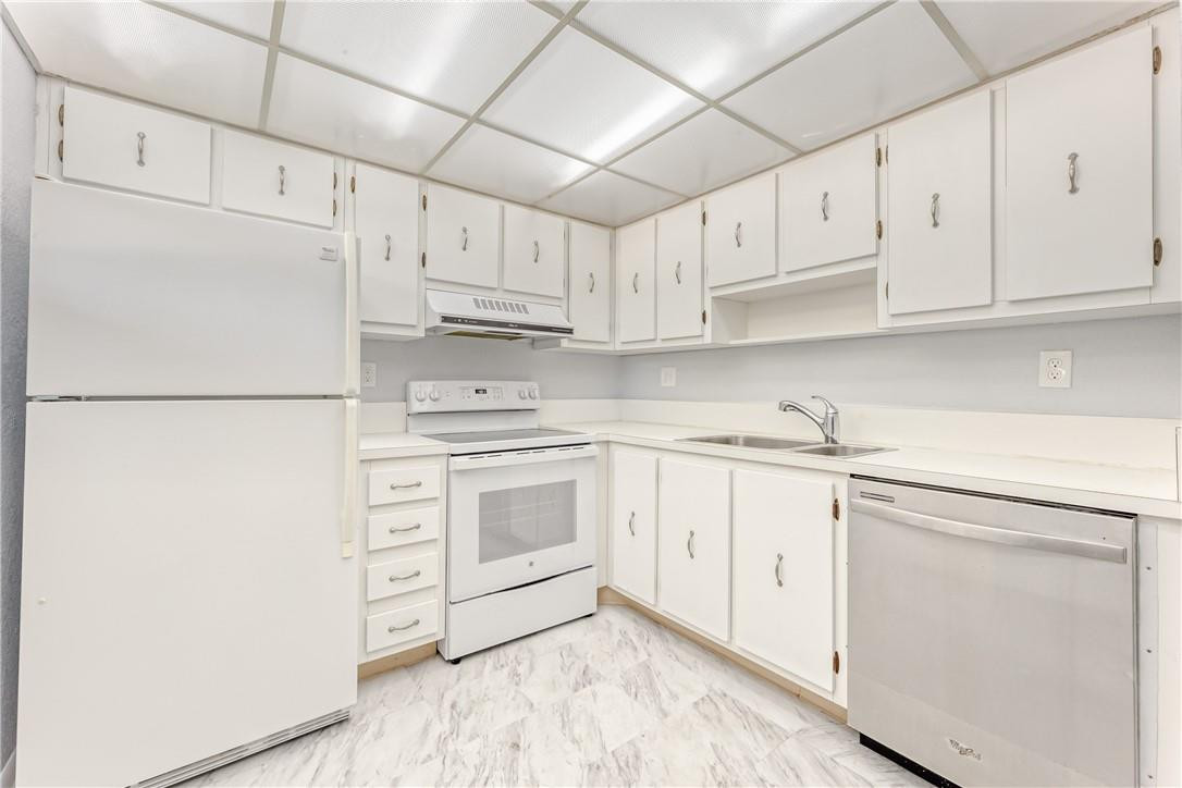 3900 Inverrary Boulevard, Unit E2 Lauderhill, FL 33319 - Photo 14 of 45 a kitchen with white cabinets and white appliances