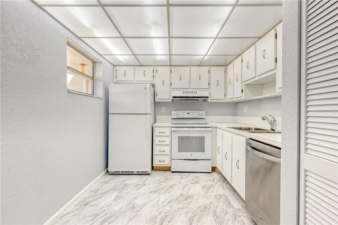 3900 Inverrary Boulevard, Unit E2 Lauderhill, FL 33319 - Photo 16 of 45 a kitchen with stainless steel appliances granite countertop a stove a refrigerator and white cabinets