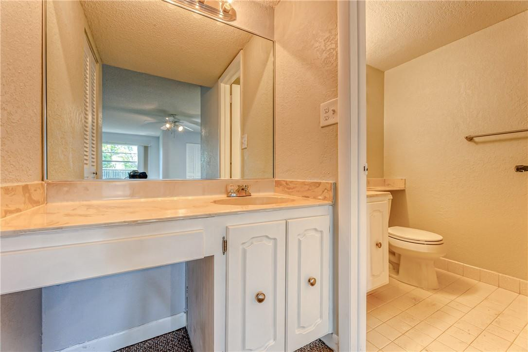 3900 Inverrary Boulevard, Unit E2 Lauderhill, FL 33319 - Photo 26 of 45 a bathroom with a granite countertop sink a toilet and a mirror