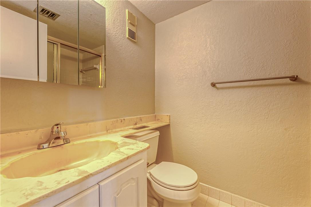 3900 Inverrary Boulevard, Unit E2 Lauderhill, FL 33319 - Photo 28 of 45 a bathroom with a granite countertop sink toilet and a mirror