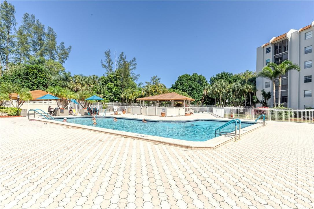 3900 Inverrary Boulevard, Unit E2 Lauderhill, FL 33319 - Photo 39 of 45 a view of a swimming pool with a yard