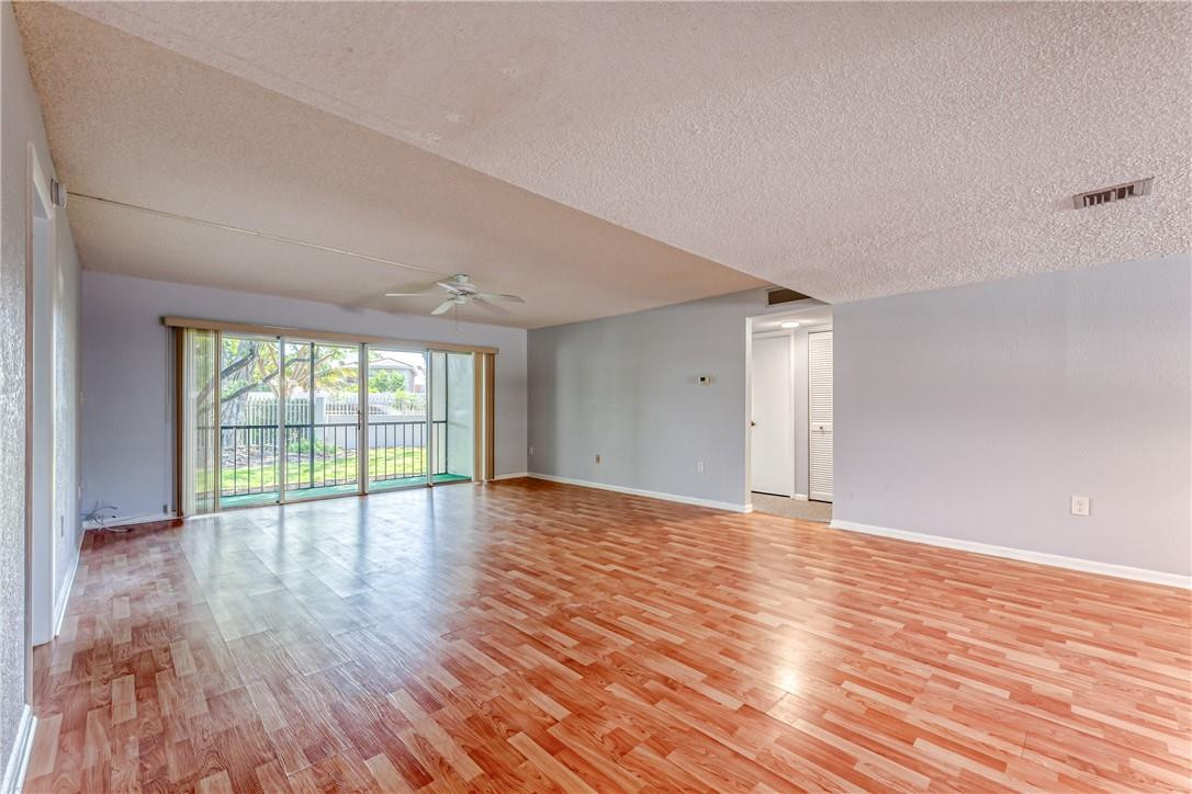 3900 Inverrary Boulevard, Unit E2 Lauderhill, FL 33319 - Photo 4 of 45 a view of an empty room with wooden floor and a window