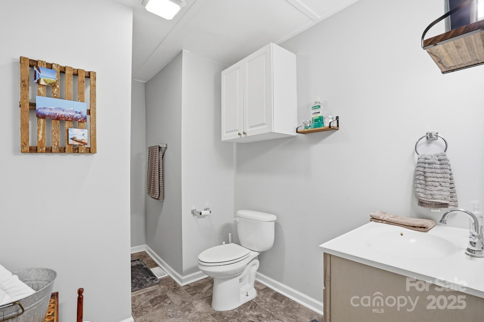 910 Roosevelt Street Badin, NC 28001 - Photo 14 of 30 a bathroom with a toilet a sink and vanity