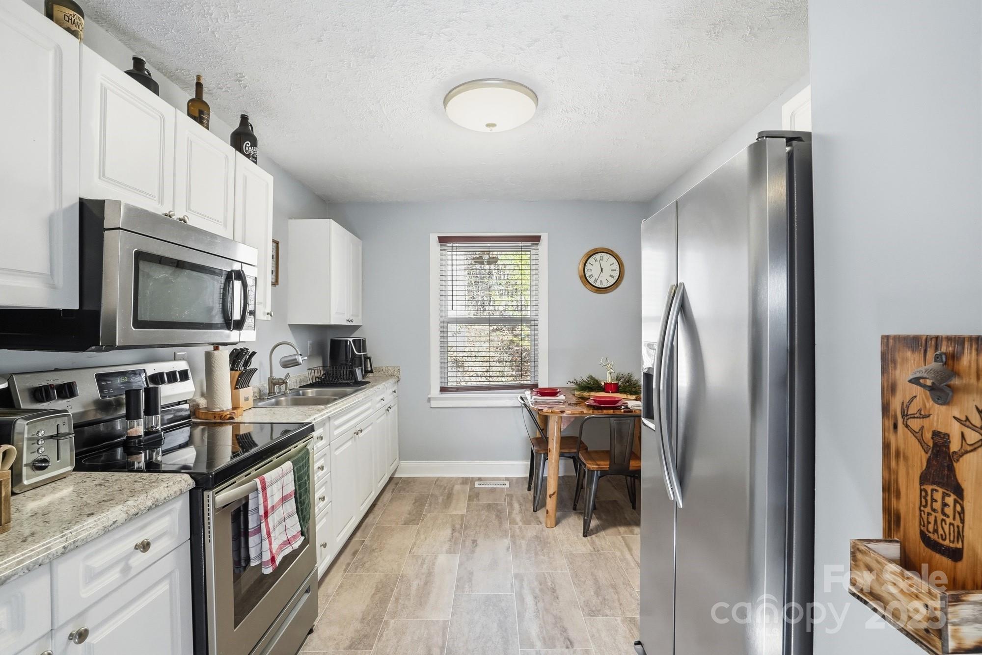 910 Roosevelt Street Badin, NC 28001 - Photo 19 of 30 a kitchen with stainless steel appliances granite countertop a refrigerator stove and a sink