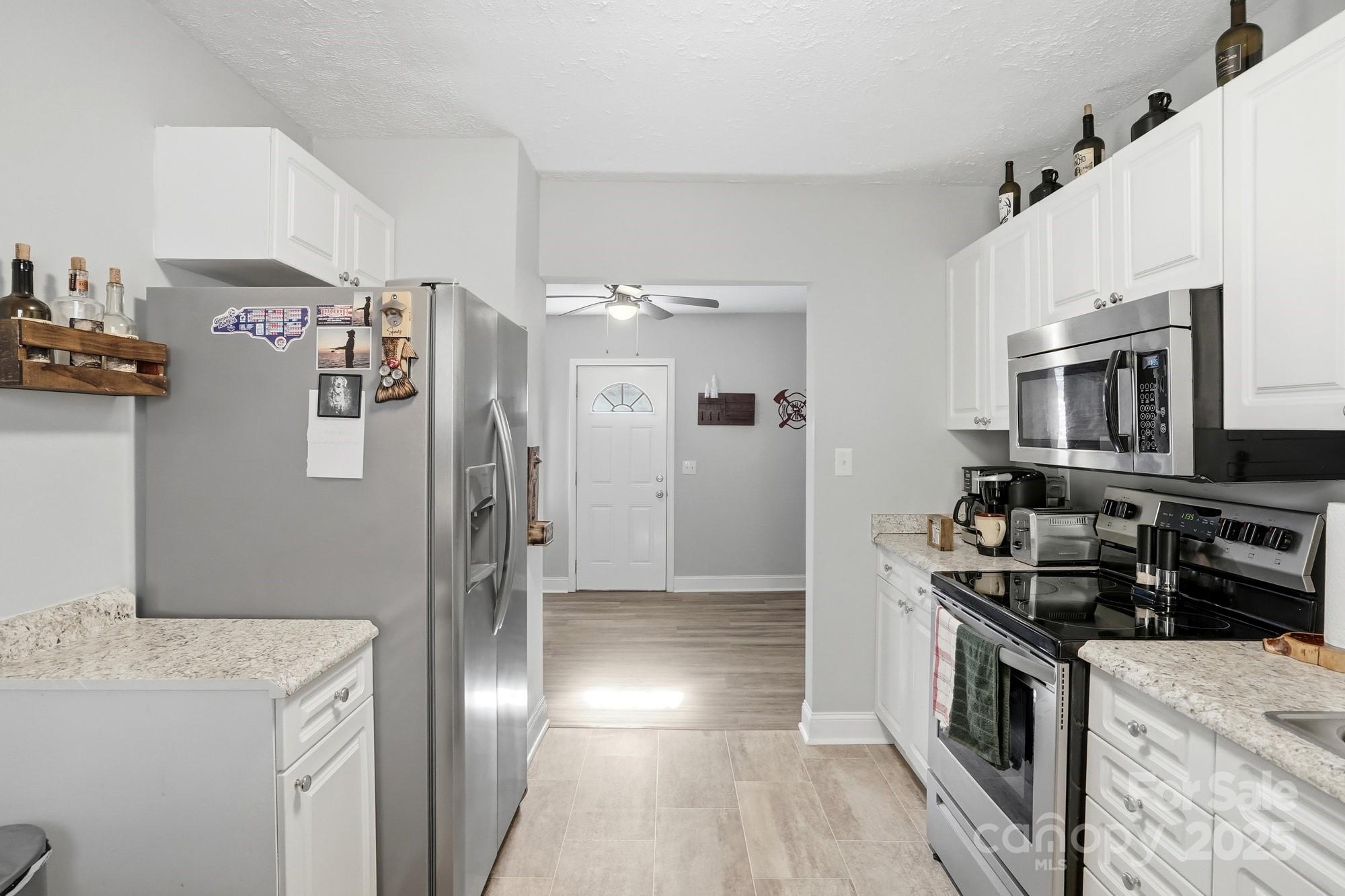 910 Roosevelt Street Badin, NC 28001 - Photo 21 of 30 a kitchen with stainless steel appliances granite countertop a refrigerator a stove and a sink