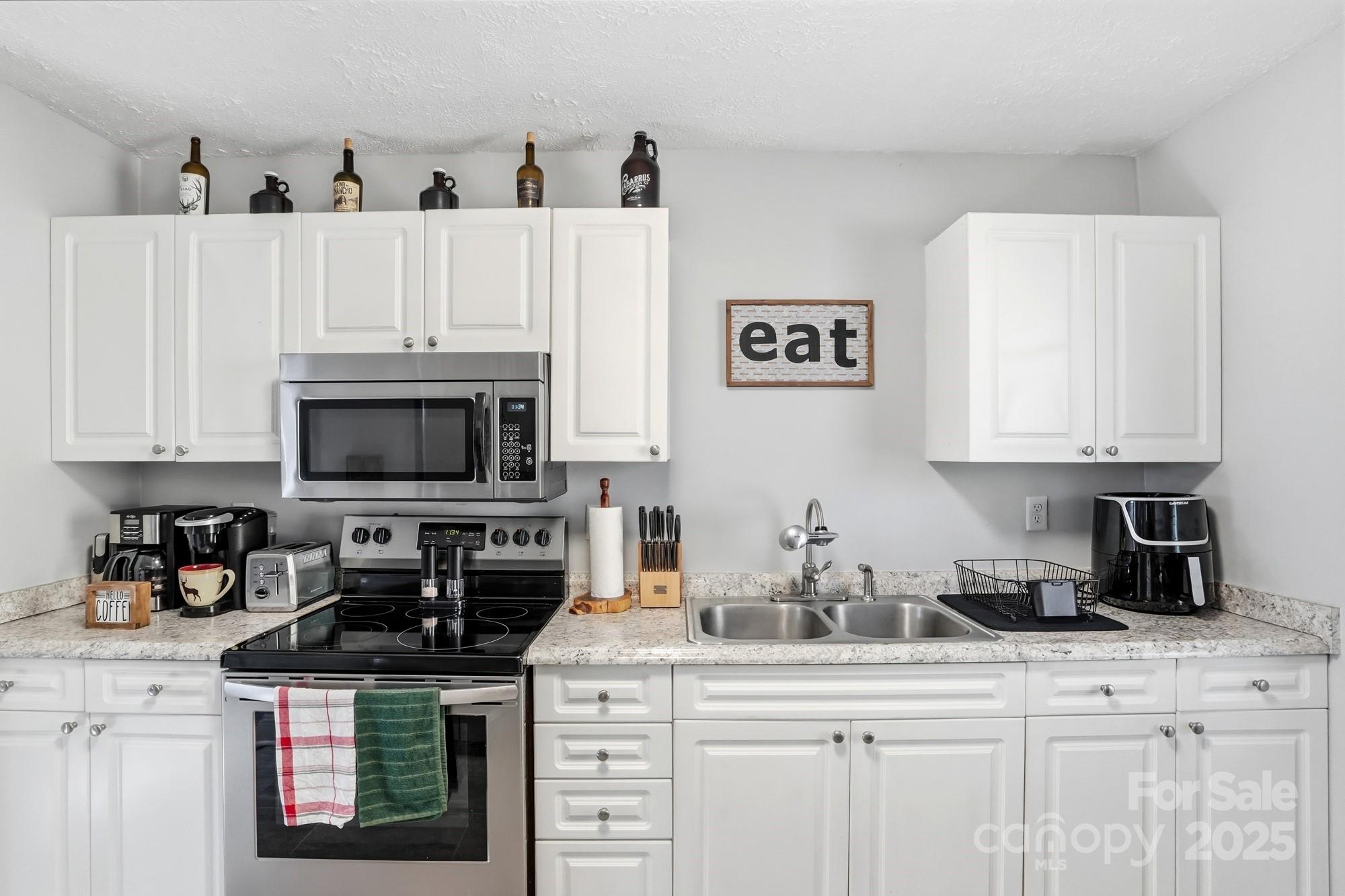 910 Roosevelt Street Badin, NC 28001 - Photo 23 of 30 a kitchen with granite countertop a sink a stove and cabinets