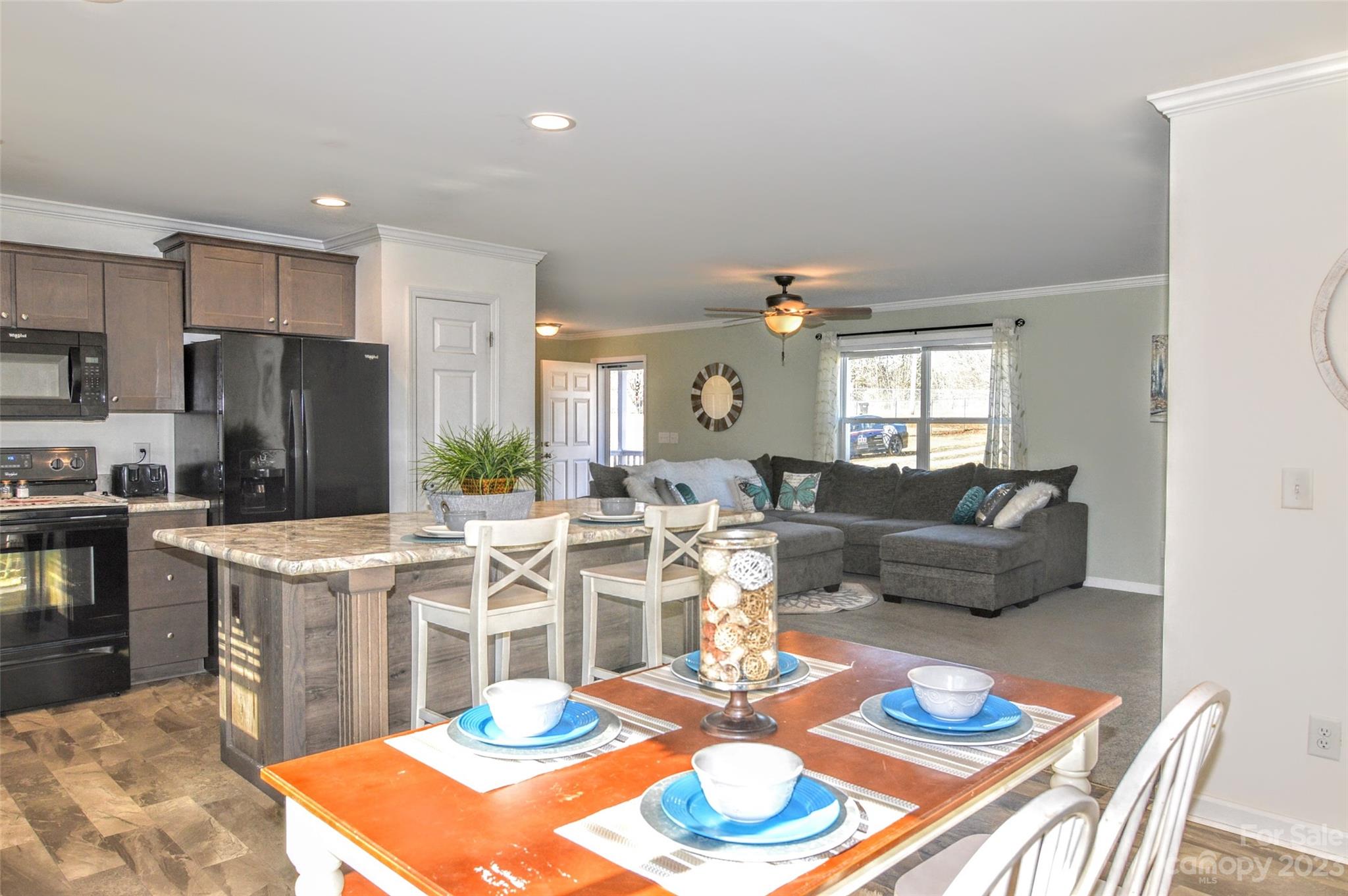 5717 Griffith Road Monroe, NC 28112 - Photo 12 of 48 a living room with furniture a rug and kitchen view