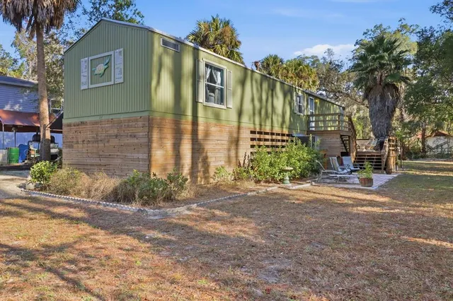 a front view of a house with a yard and potted plants