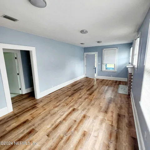 a view of empty room with wooden floor