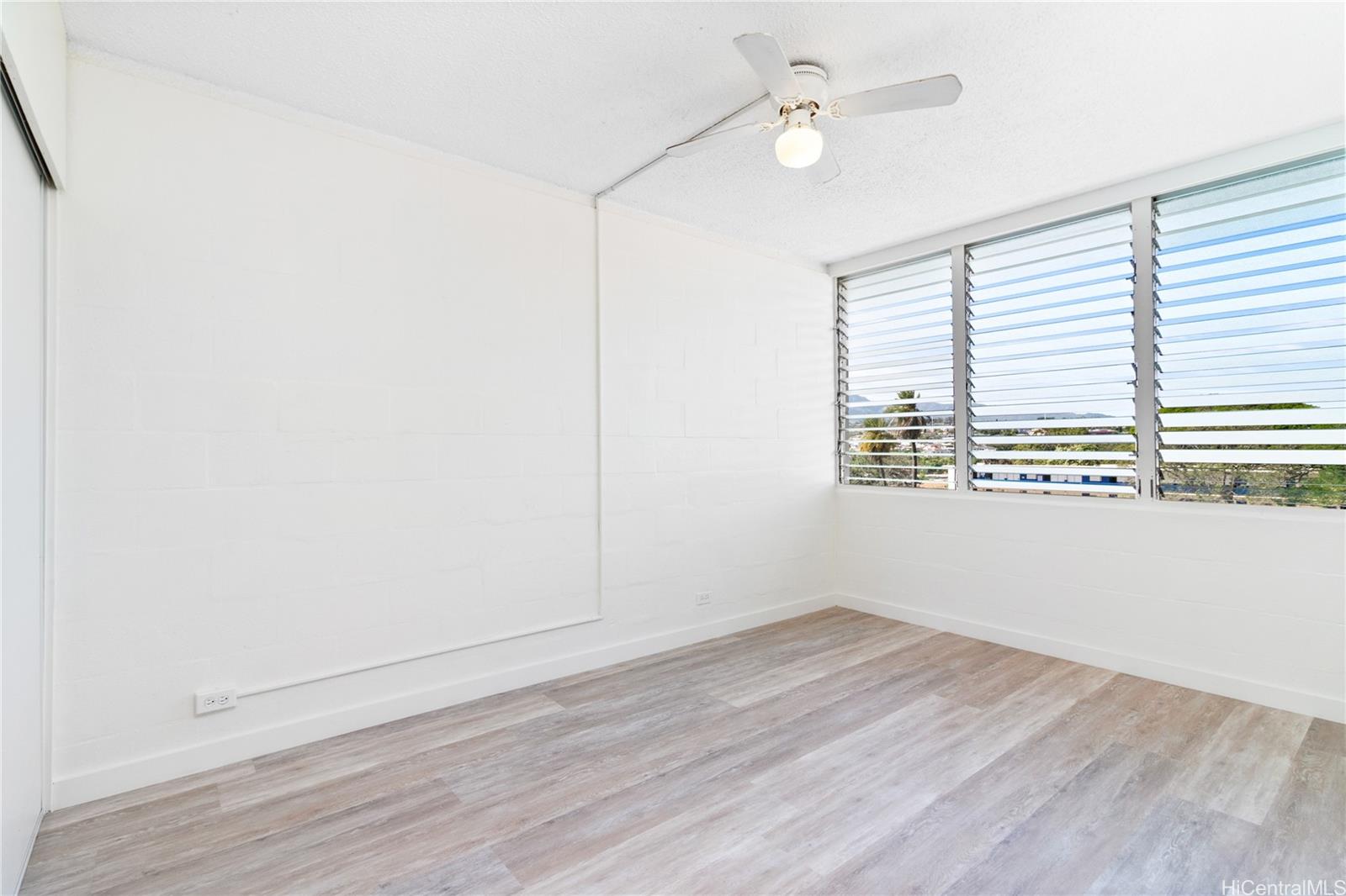 94-249 Waikele Road, Unit A307 Waipahu, HI 96797 - Photo 10 of 20 an empty room with wooden floor fan and windows