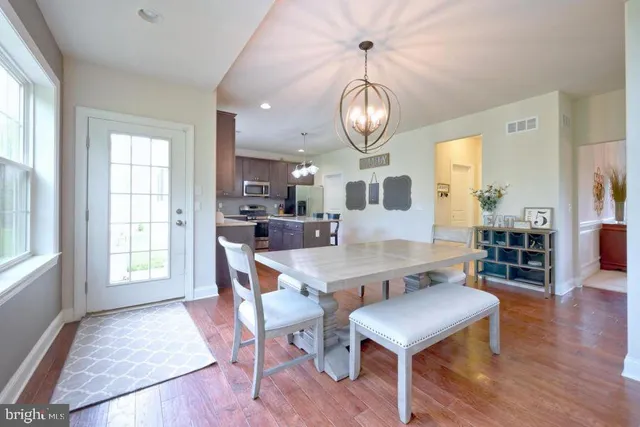 a view of a dining room with furniture a chandelier and a window