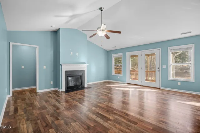 a view of an empty room with window and fire place