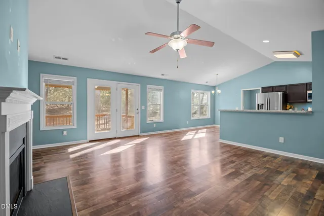 a view of an empty room with a fireplace and a window