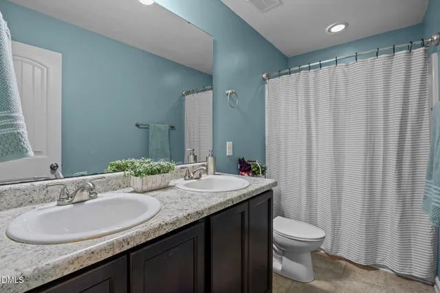 a bathroom with a granite countertop sink and a mirror with toilet