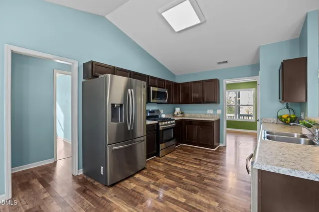 a kitchen with granite countertop a refrigerator stove and oven