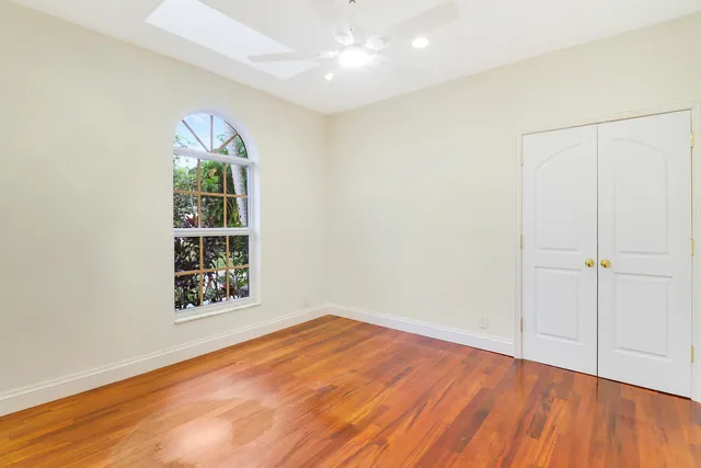 an empty room with window and wooden floor