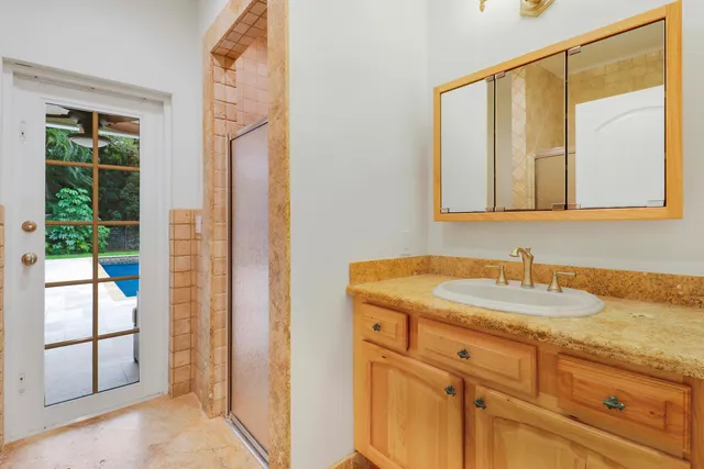 a bathroom with a granite countertop sink and a mirror