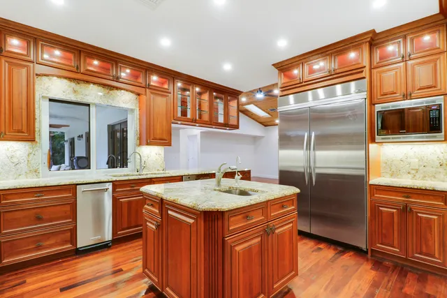 a kitchen with stainless steel appliances granite countertop a sink and a refrigerator