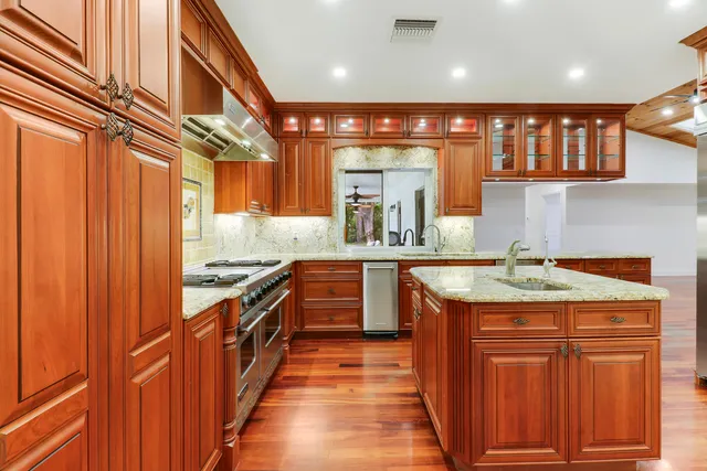 a kitchen with stainless steel appliances granite countertop a sink and wooden cabinets