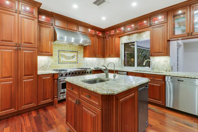 a kitchen with stainless steel appliances granite countertop a sink stove and cabinets