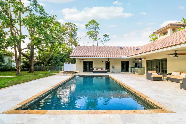 a view of a house with swimming pool and sitting area
