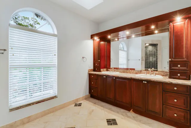 a spacious bathroom with a granite countertop sink and a large mirror
