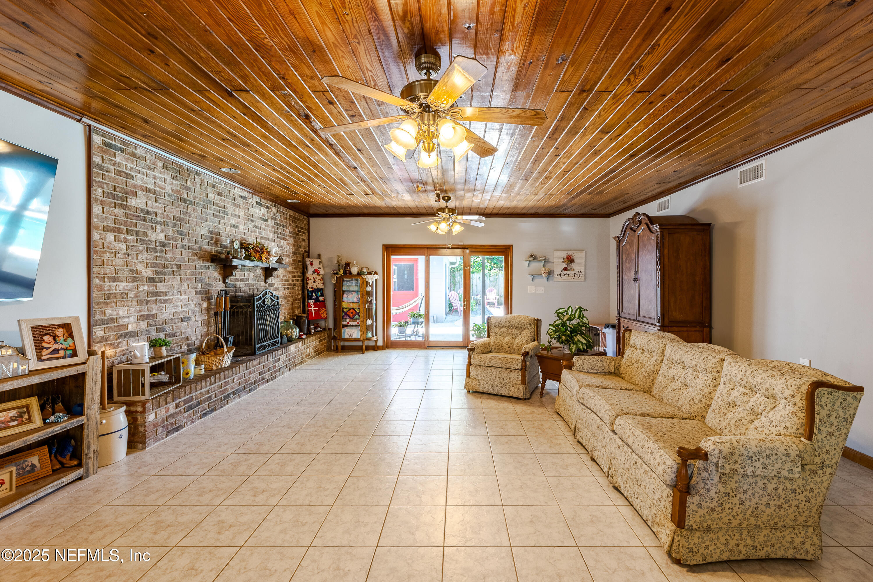 6542 Ovington Road South Jacksonville, FL 32216 - Photo 22 of 35 a living room with furniture a chandelier and a fireplace