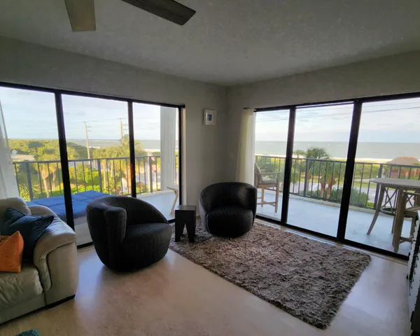 a living room with furniture and a floor to ceiling window